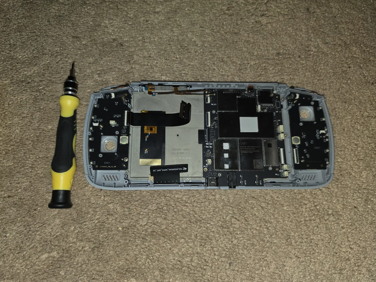 A partially disassembled Odin 2 beside a screwdriver